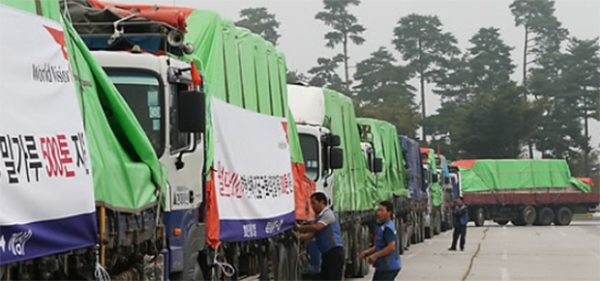 국제구호단체 월드비전의 대북수해지원 밀가루 500t을 실은 트럭들이 줄지어 있다(사진 RFA 폼페이지).